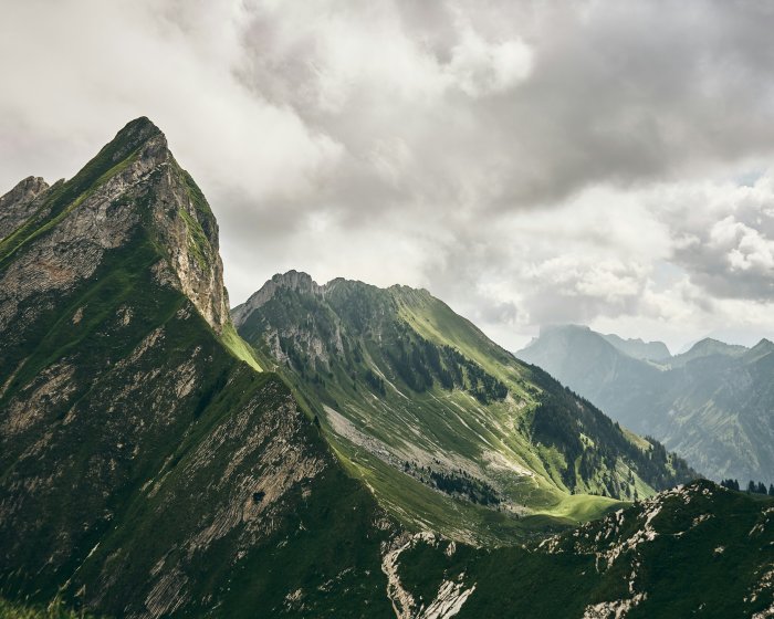 Green mountain peaks under a cloudy sky