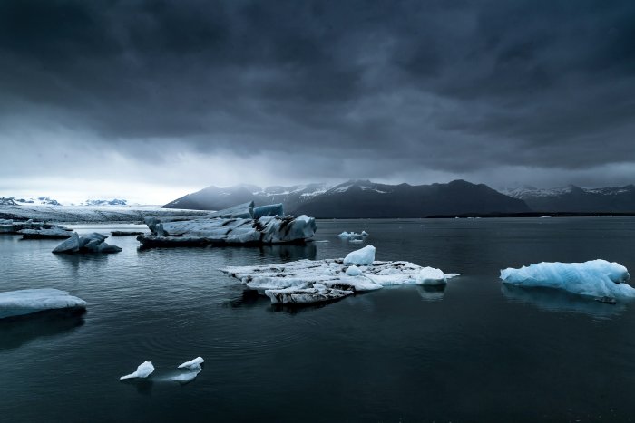 Icebergs floating in a dark glacial lagoon