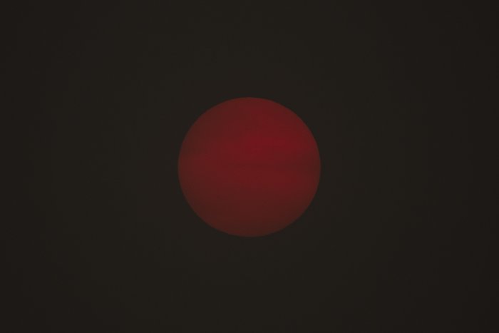 Dark red sun obscured by thick wildfire smoke