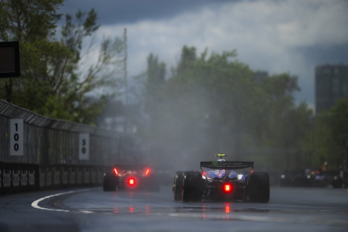 Formula One Cars Racing on a Wet Track