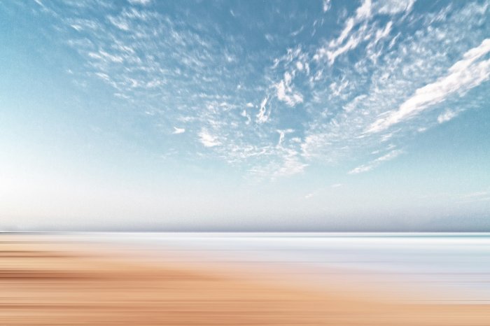 Minimalist motion blurred sand coastline and blue sky