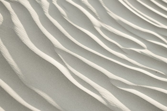 Wavy patterns on white sand dunes