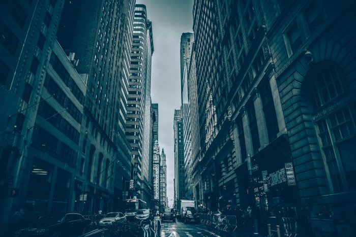 Dark moody city street with towering skyscrapers