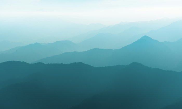 Layered blue mountain ridges in morning mist