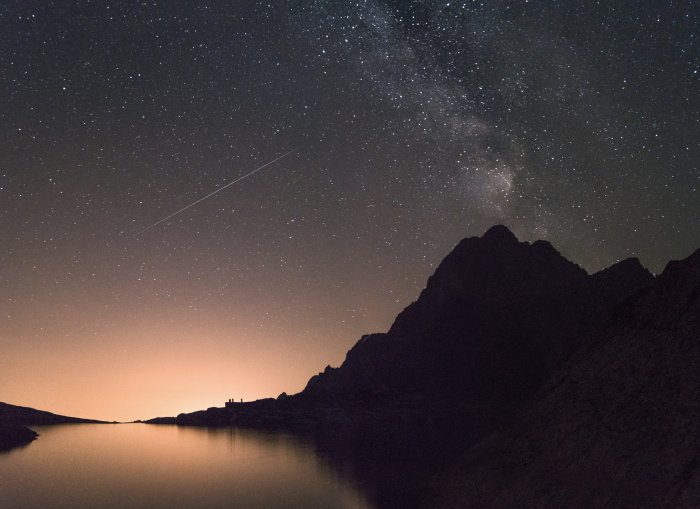 Starry Night Sky Over Mountain Silhouette and Lake