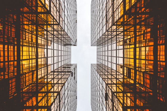 Worm's-eye view of orange reflective glass skyscrapers