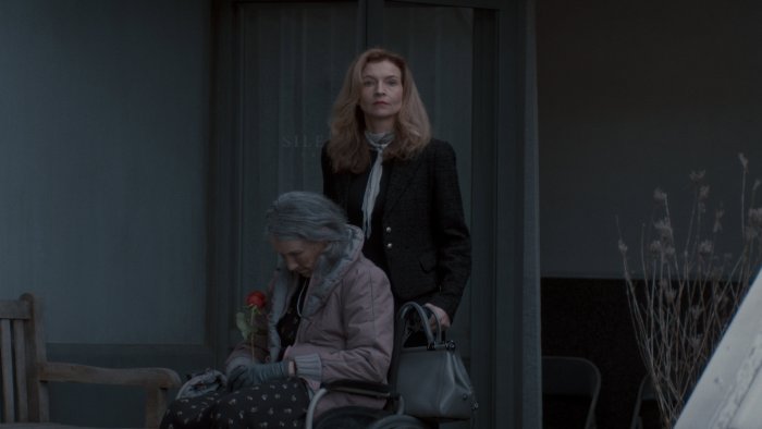 Two women outside a building, one in a wheelchair