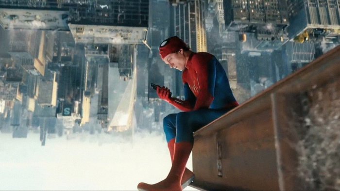 Spider-Man looking at his phone in No Way Home