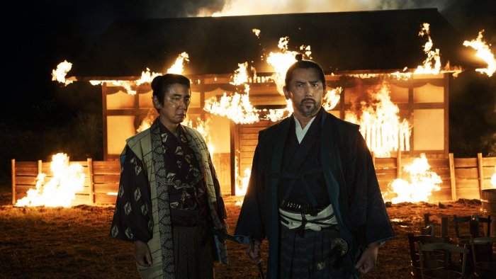 Samurai standing before a burning building