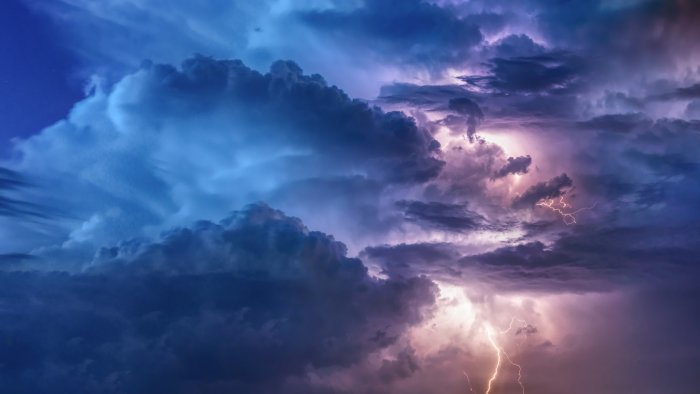 Thunderstorm clouds illuminated by lightning flashes