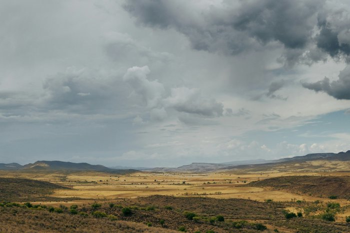 Arid valley landscape under dramatic storm clouds