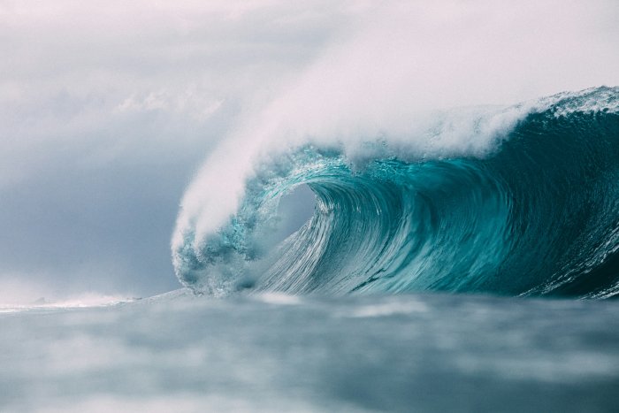 Powerful blue ocean wave curling into a barrel