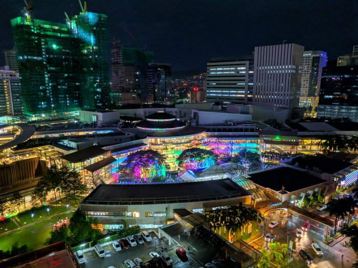 Night View of Illuminated City Buildings and Colorful Plaza