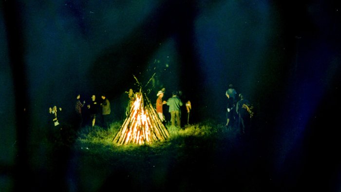 People gathered around a large bonfire in Camp