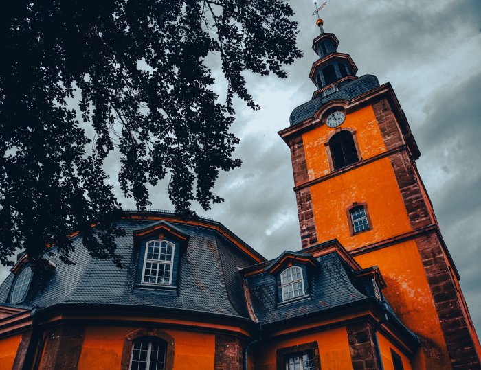 Orange Clock Tower and Building Under Cloudy Sky