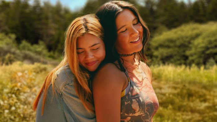 Two women hugging in a field from Girls Like Girls