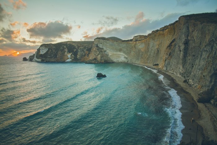 Coastal cliffs and turquoise bay at sunset