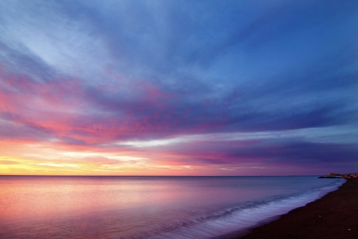 Sunrise over calm ocean beach with colorful sky