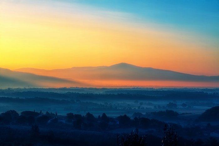 Mountain silhouettes during a colorful misty sunrise