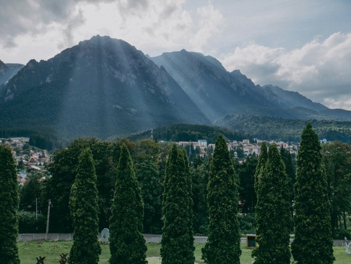 Sunbeams over Carpathian Mountains and Romanian Town