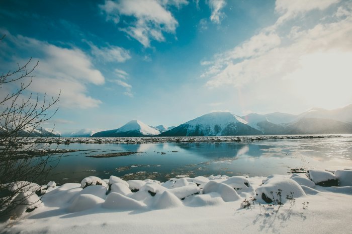 Snow-covered mountains reflecting in calm winter water