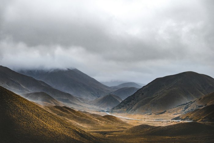 Winding road through golden hills and misty mountains