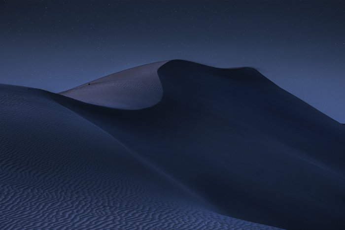 Sand dunes under a starry night sky