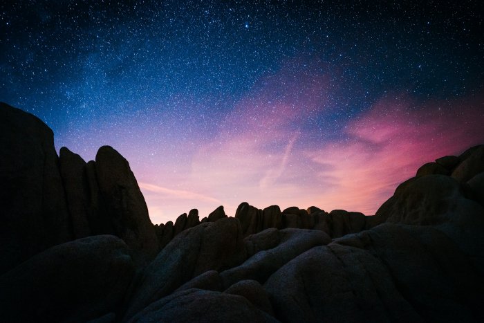Starry night sky over rock formations in Joshua Tree