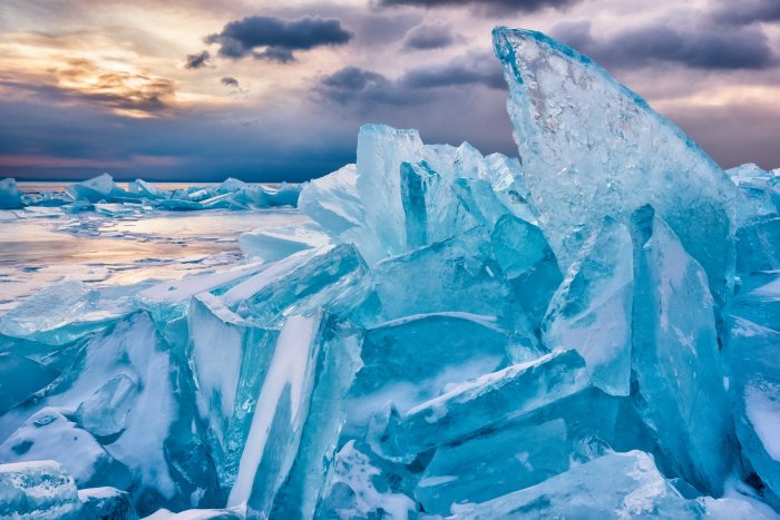 Turquoise ice hummocks on a frozen lake at sunset