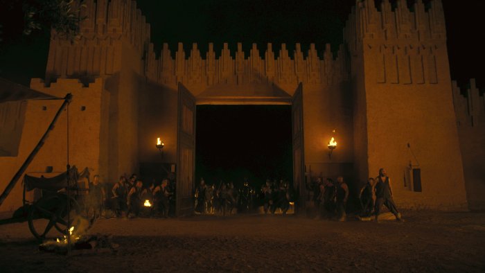 Ancient city gates at night in The Odyssey