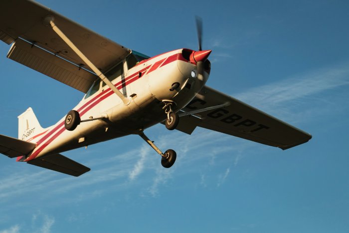 White and Red Propeller Airplane Flying in Blue Sky