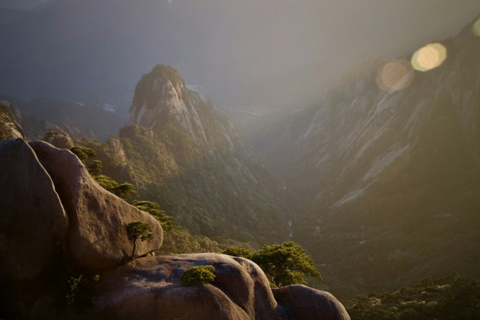 Sunlit granite peaks and forested mountain valley