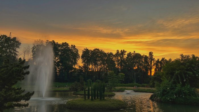 Garden Pond with Fountains at Sunset