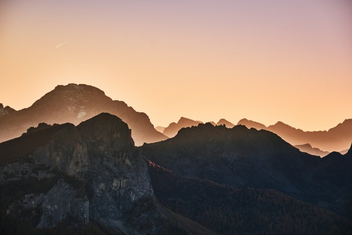 Rocky mountain peaks silhouetted against a sunset sky