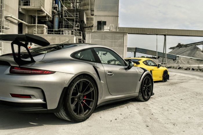 Silver and Yellow Porsche Sports Cars at Industrial Site