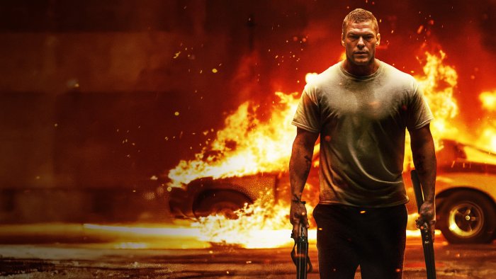 Alan Ritchson holding weapons in Motor City