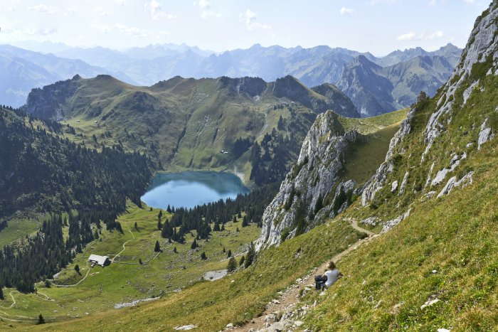 Hiker overlooking Oberstockensee lake in Swiss mountains