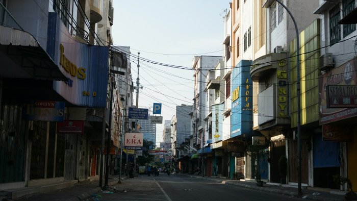 Narrow City Street with Shopfronts and Overhead Wires