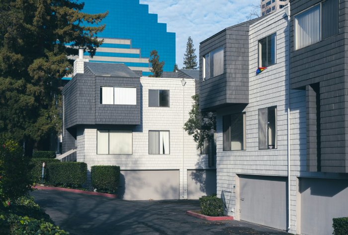 Modern townhouses with blue skyscraper in the background