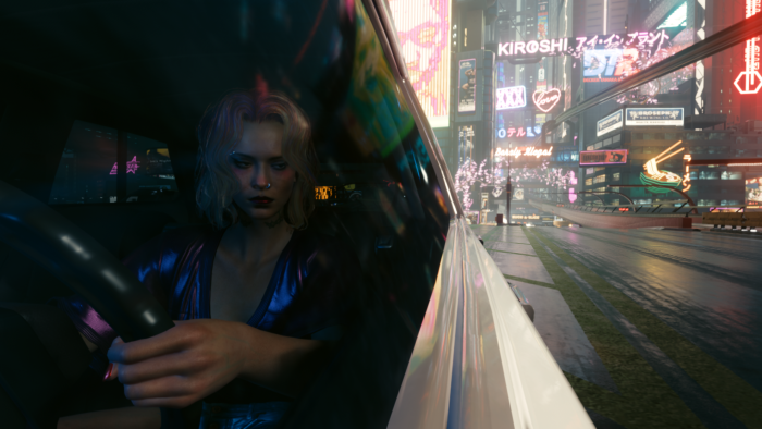 Female V driving through Night City in Cyberpunk 2077
