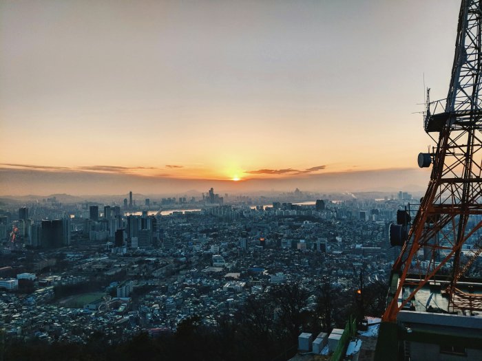 City skyline at sunset with transmission tower