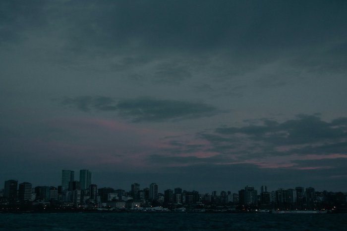 City skyline under dark cloudy sky at dusk