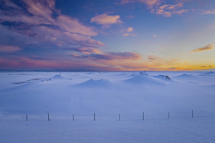 Snowy Winter Landscape at Sunset with Fence
