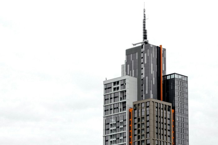 Modern skyscraper with antenna against overcast sky