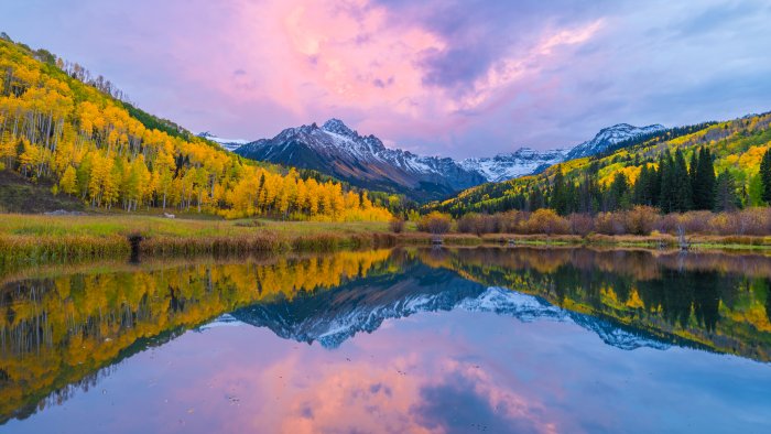 Autumn mountains and yellow trees reflected in lake