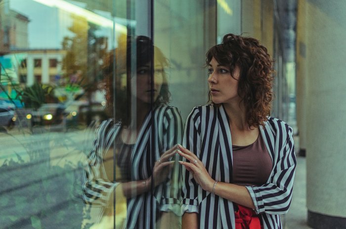 Woman looking at her reflection in a glass window