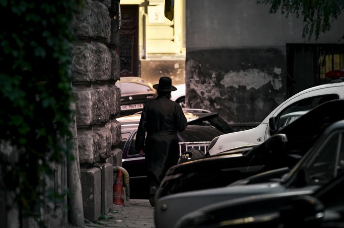 Man in Hasidic Attire Walking Down City Street