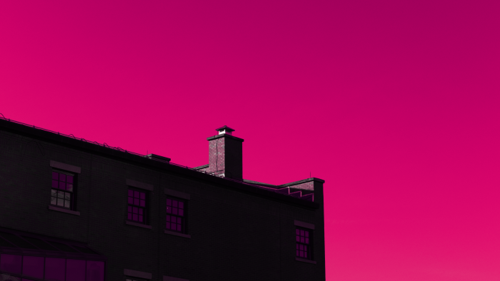 Dark building silhouette against a bright magenta sky