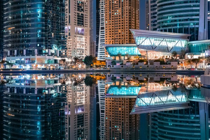 Modern City Skyscrapers Reflected in Water at Night