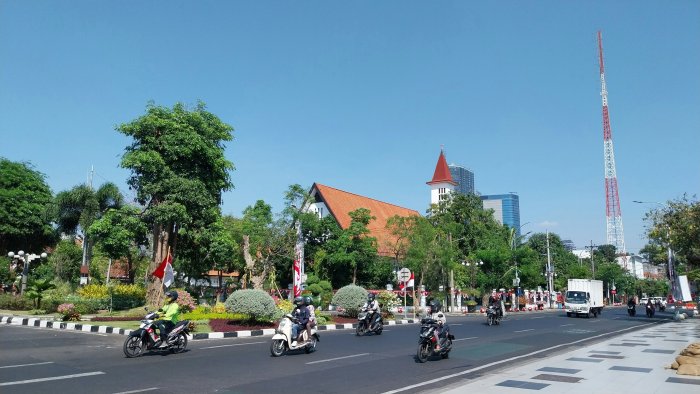 Motorcyclists riding on a city street in Indonesia